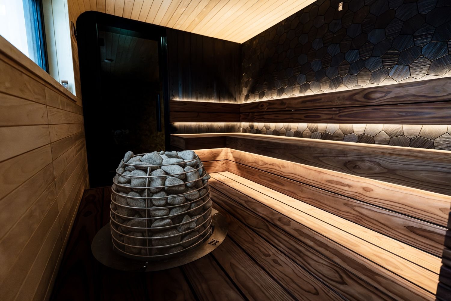 Sauna en bois avec poêle à pierres, chaleur sèche pour la détente et la récupération