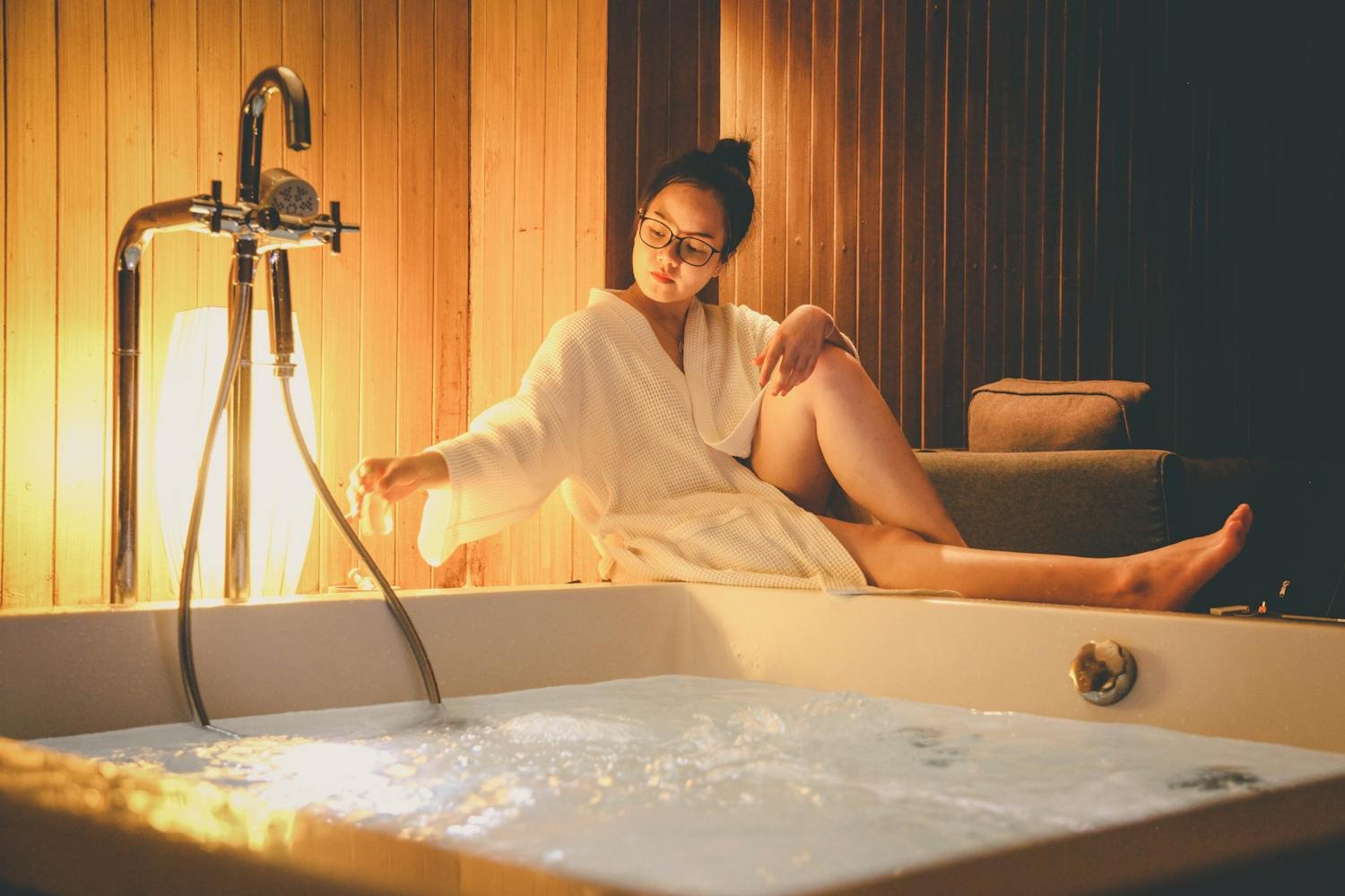 Moment de détente en peignoir près d'un jacuzzi privatif dans une suite bien-être
